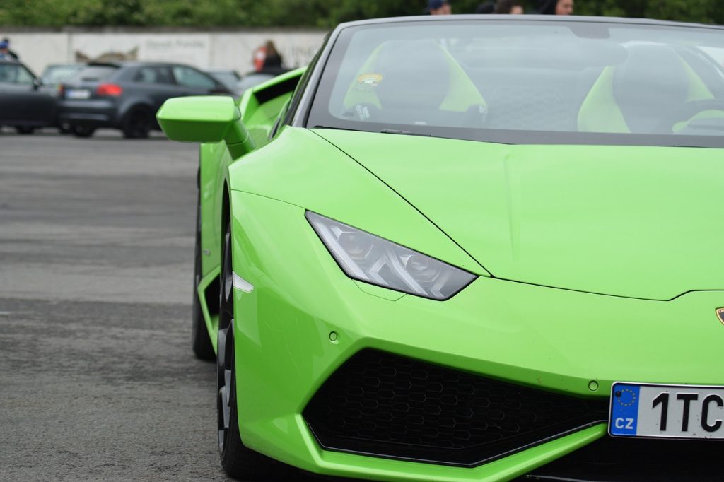 A striking green Lamborghini Huracán Spyder with Czech plates stands out in a parking lot, showcasing exotic performance and street-legal presence.