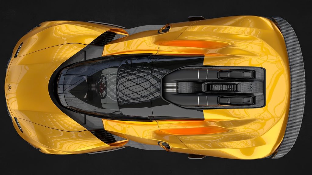 A top-down view of a sleek, gold hypercar showcases its aerodynamic curves, central glass canopy, and exposed rear engine bay with carbon fiber detailing.